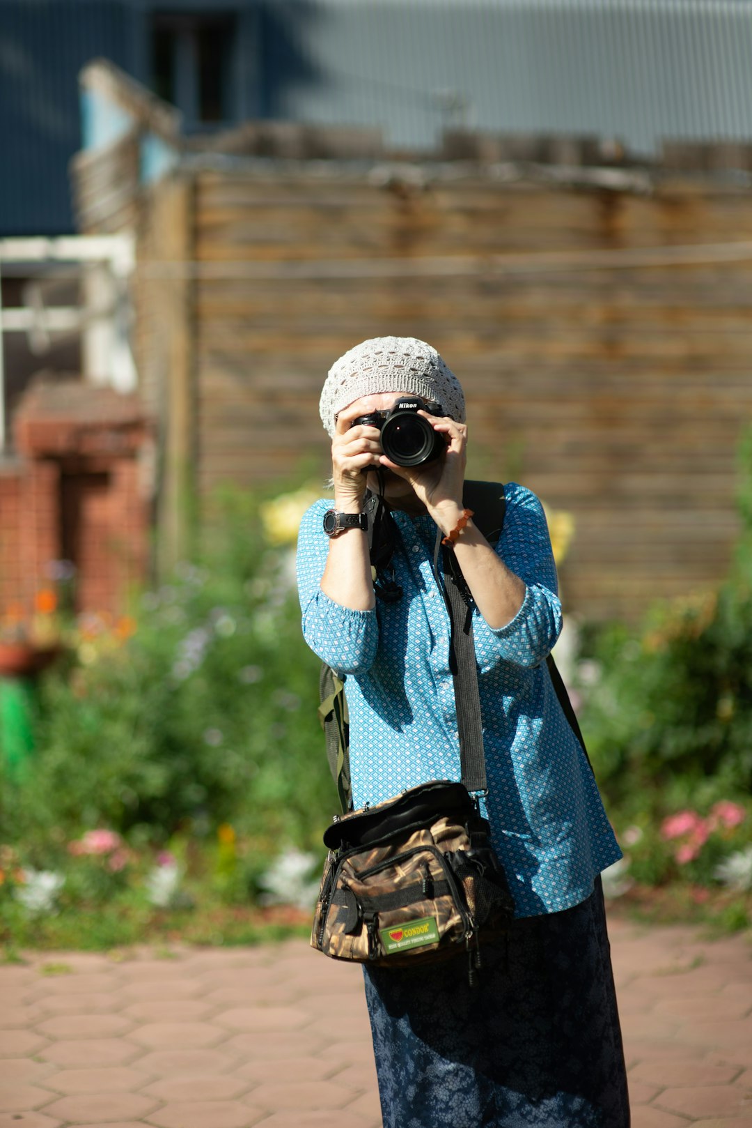 woman in blue and white knit sweater holding black dslr camera
