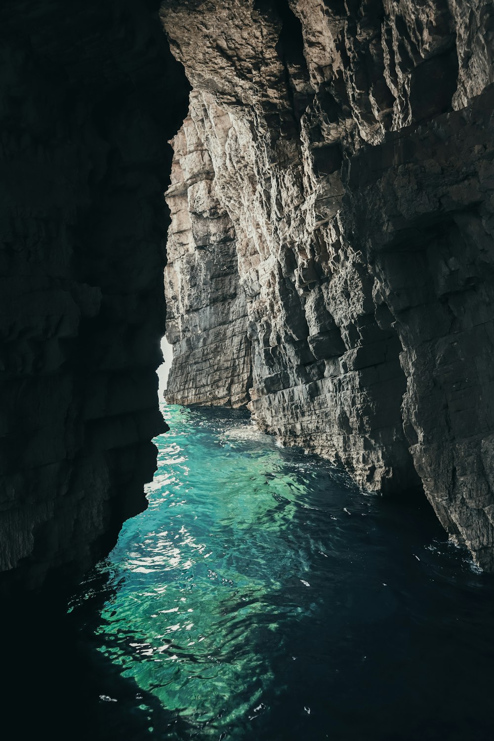 Specchio d'acqua vicino alla formazione rocciosa marrone durante il giorno