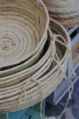 Stack of woven baskets in varying sizes and natural shades of beige and brown.