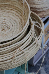 Natural jute baskets and trays arranged on a beige linen cloth with terracotta pottery.