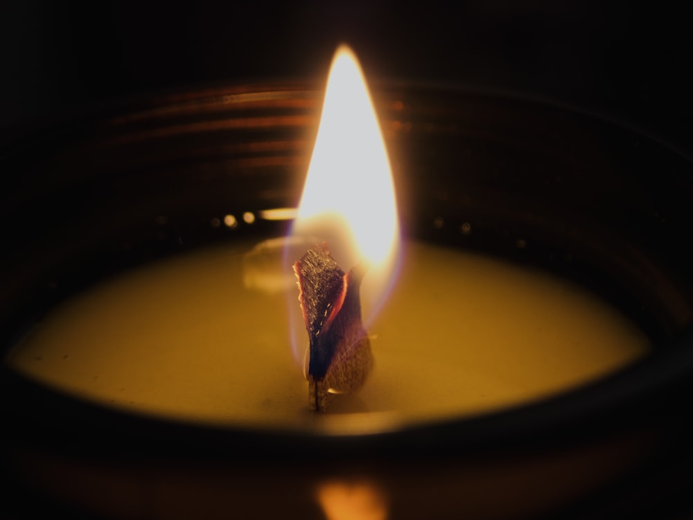 lighted candle in black round container