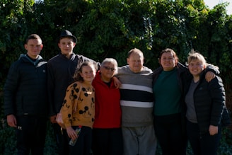 group of people standing near green trees during daytime