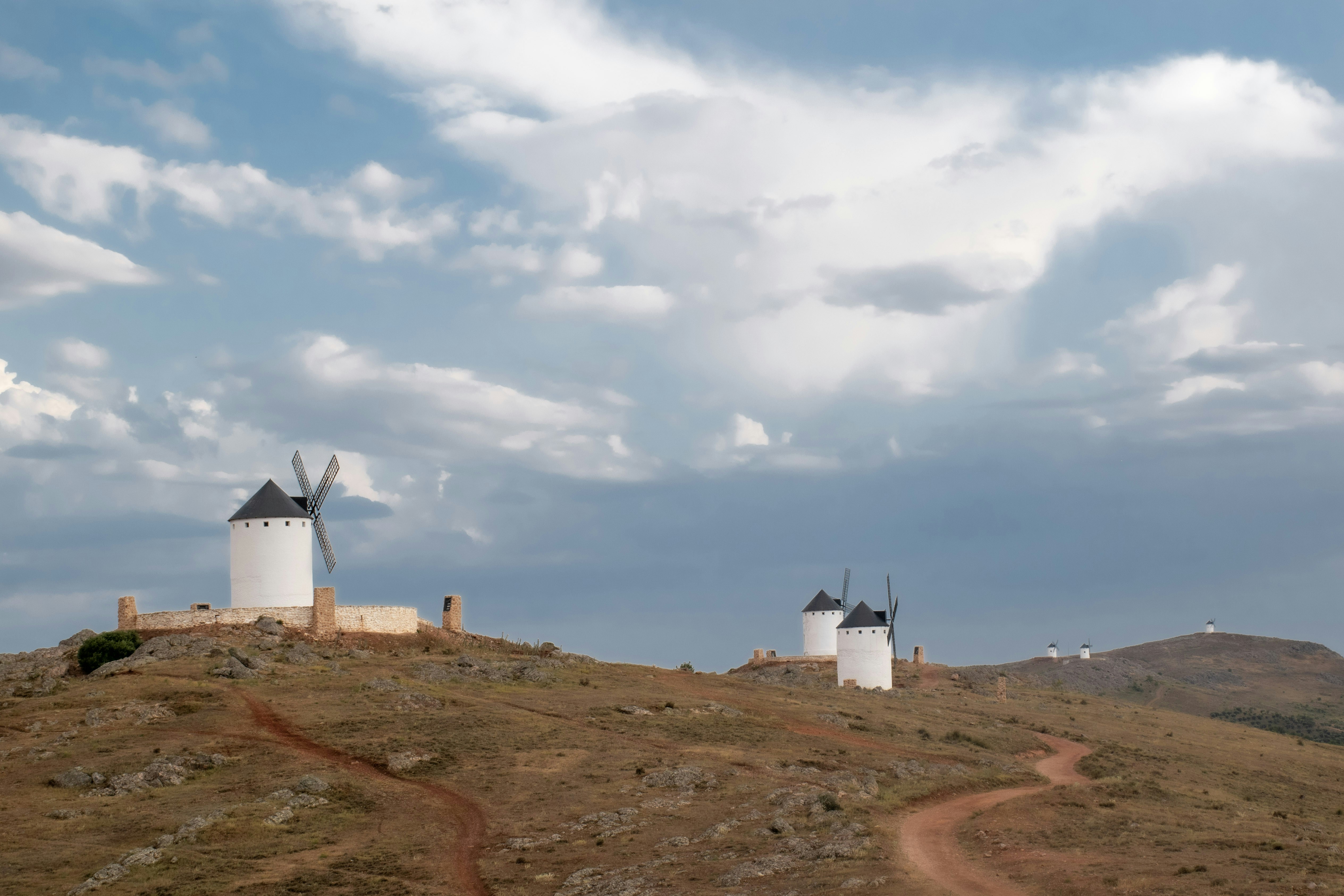 white lighthouse on brown field under white clouds and blue sky during daytime