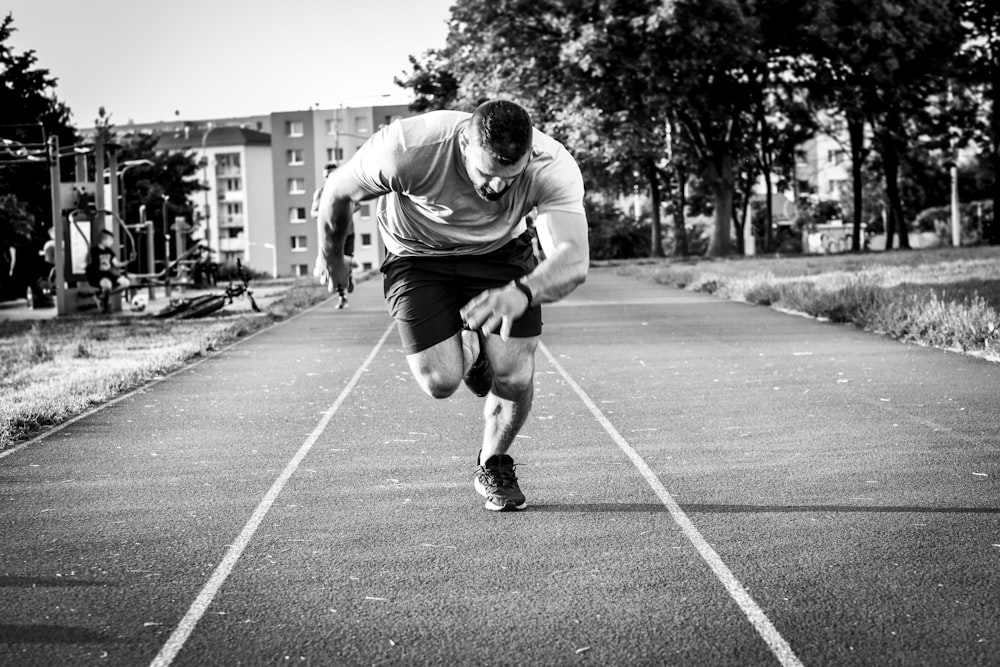 man in gray long sleeve shirt and black shorts running on road during daytime