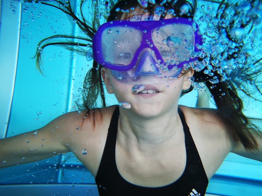 woman in black tank top wearing blue goggles