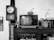 A retro setting featuring an old television displaying Chinese characters and the phrase 'BOOK RESCUES YOU'. A small pumpkin is placed on top of the TV. To the left, a vintage wooden wall clock shows the time. A floral decoration and some figurines are positioned next to the TV on a wooden cabinet. Books and a decorative flower in a pot are also visible.
