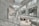 The image depicts a modern, spacious interior with curved architectural features and large glass windows. The space is characterized by sleek, white surfaces and minimalist design elements. There are a few people visible in the distance, adding a sense of scale to the large, open area.