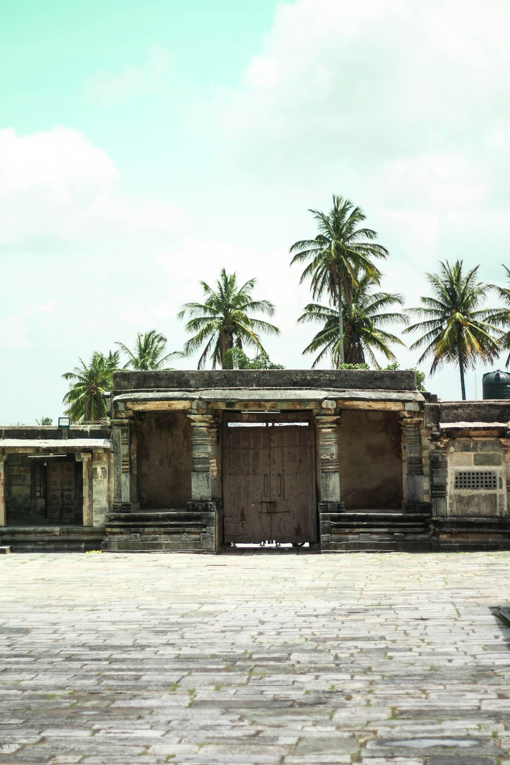 brown concrete building near palm trees during daytime