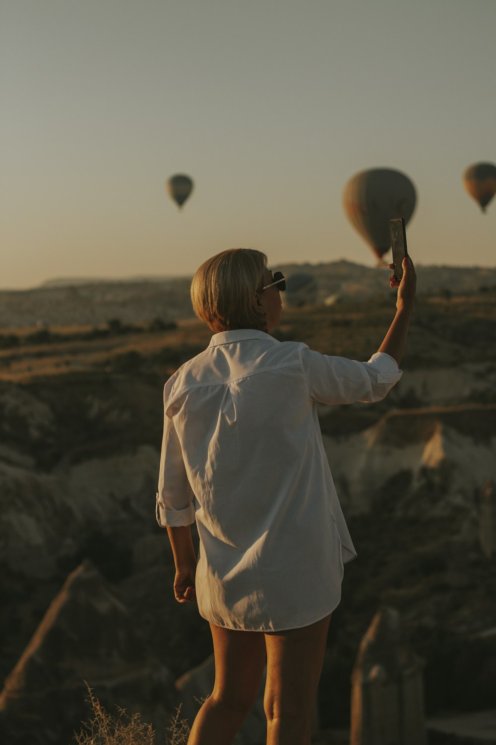 woman in white shirt holding white balloon during daytime