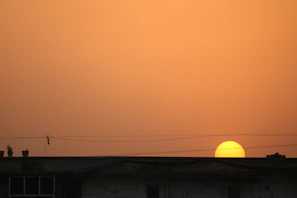 Wide shot of an emergency power plant setup next to a building at sunset