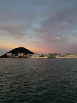 A calm harbor scene at sunset with cargo ships docked, reflecting maritime professionalism.