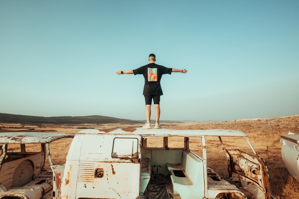 man in black shirt standing on white van during daytime