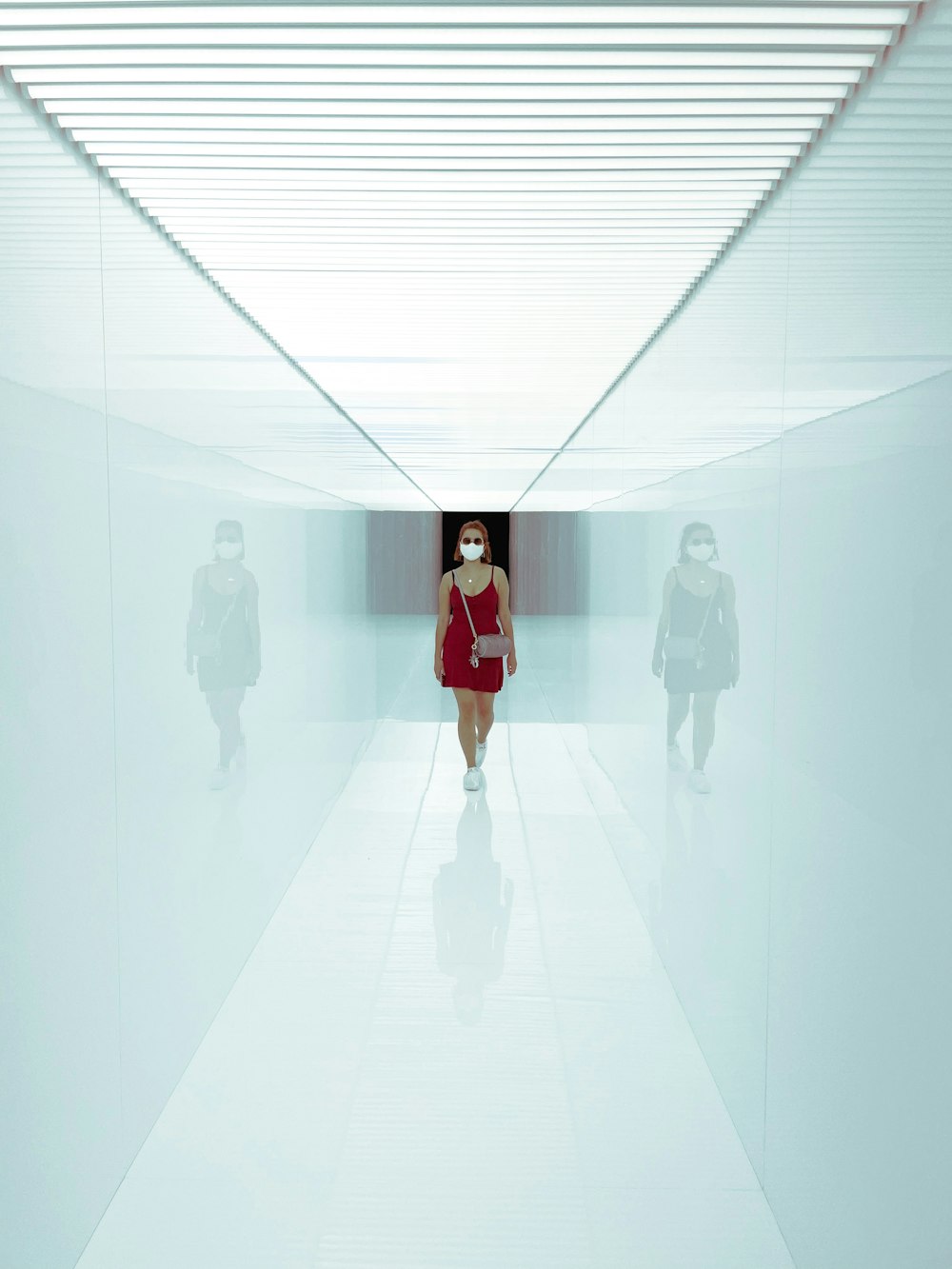 donna in vestito rosso in piedi sul pavimento bianco