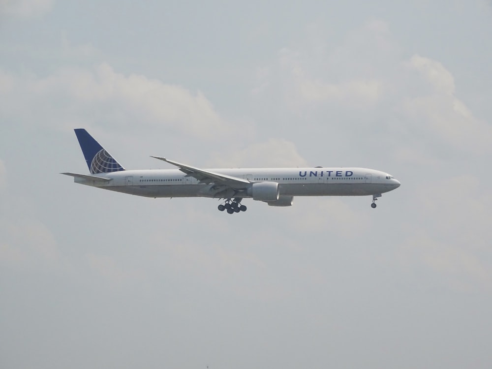 white and blue airplane in the sky