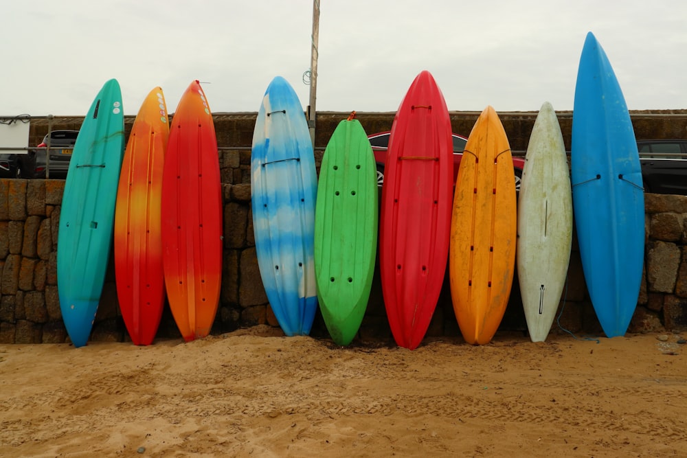 Tabla de surf azul y blanca sobre arena marrón durante el día