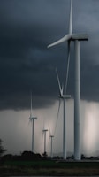white wind turbine under gray sky