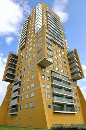 Brown multi-story condo building under a clear blue sky, similar to attached housing found across the Las Vegas Valley
