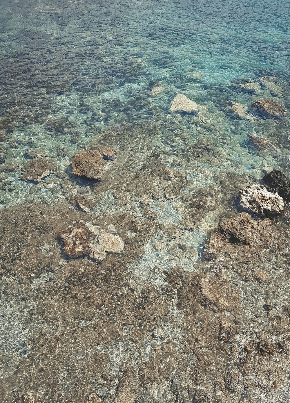 brown and gray rock formation on body of water during daytime