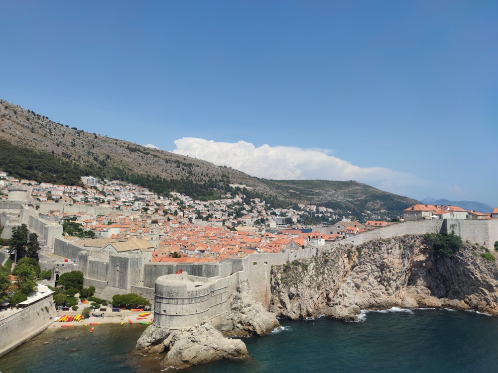 white and brown concrete buildings near body of water under blue sky during daytime