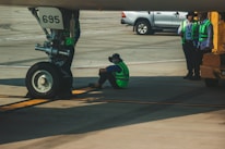 Technicians coordinating aviation ground equipment maintenance on a tarmac.