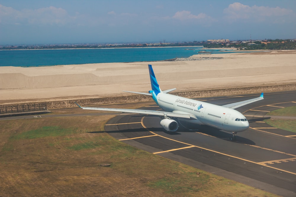 white and blue airplane on airport during daytime