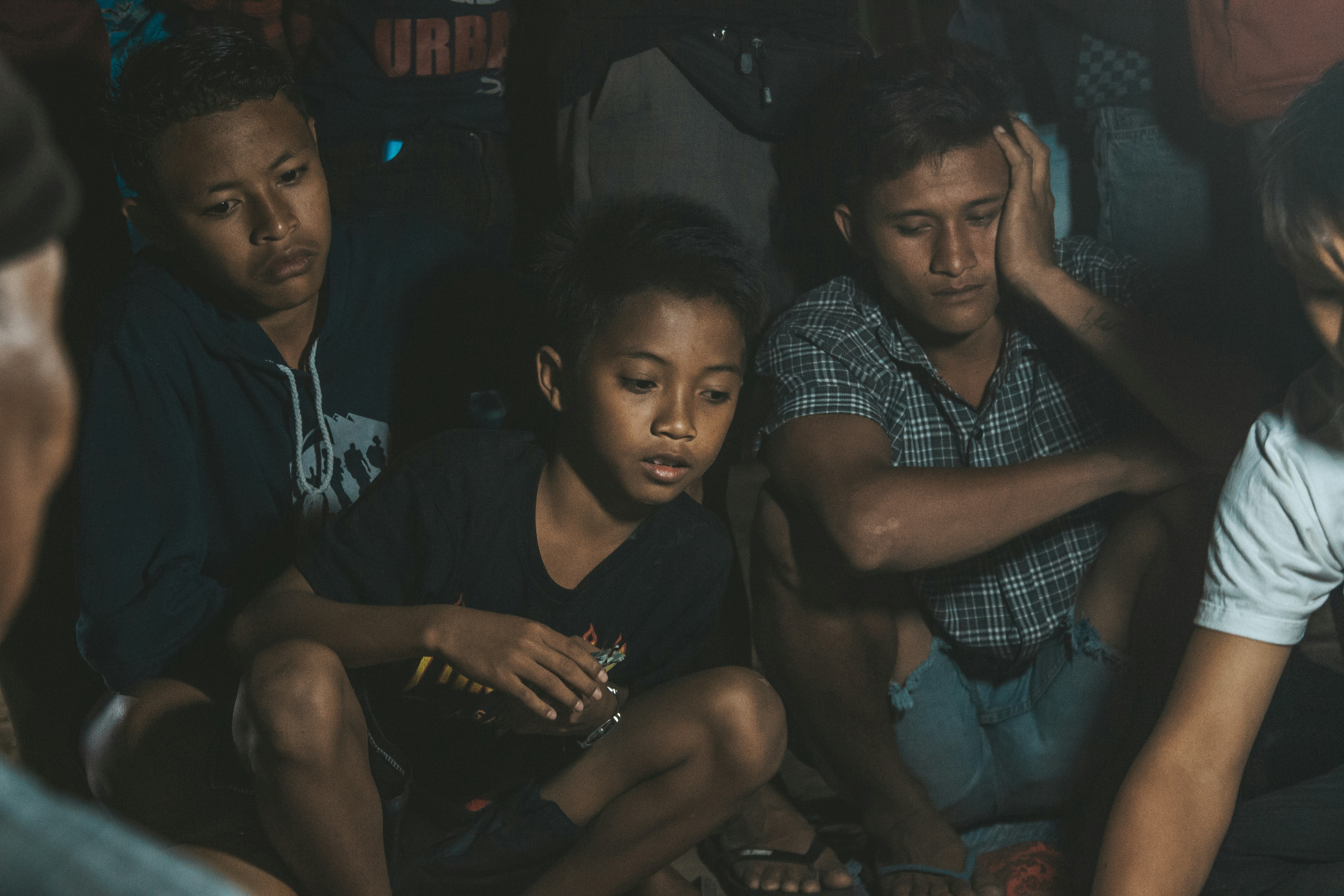man in black and white stripe polo shirt sitting beside boy in black and white stripe