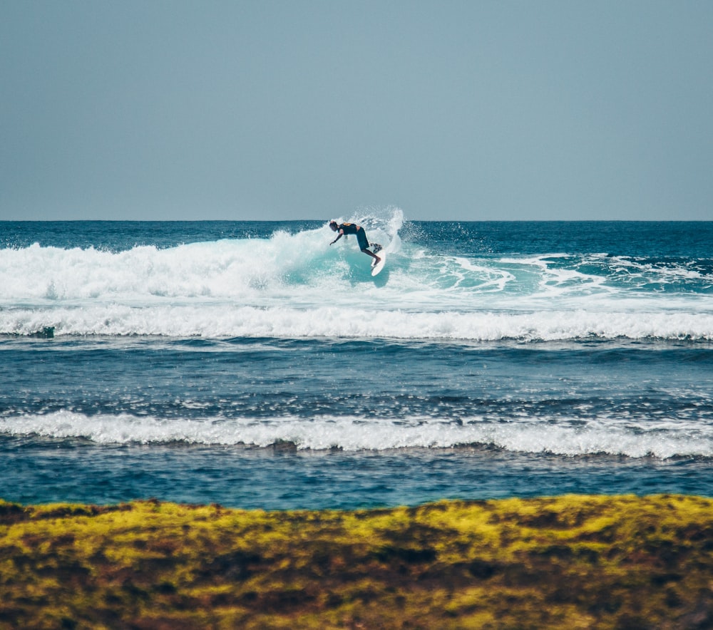 person surfing on sea waves during daytime