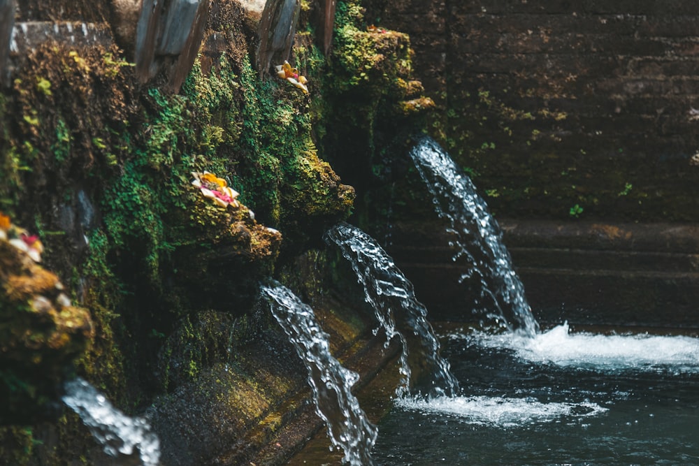 water falls in the middle of brown rocky mountain