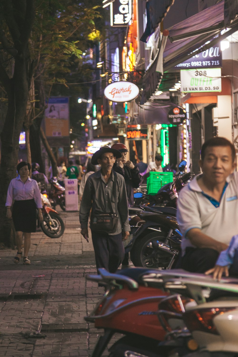 man in white polo shirt sitting on motorcycle during night time