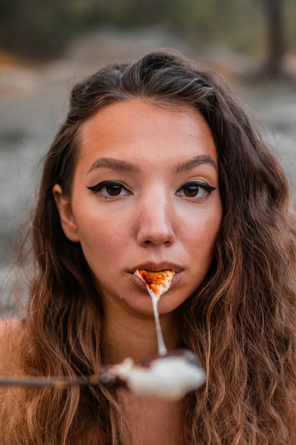 woman with brown hair eating orange food