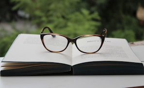 A serene blue background with scattered books and reading glasses.