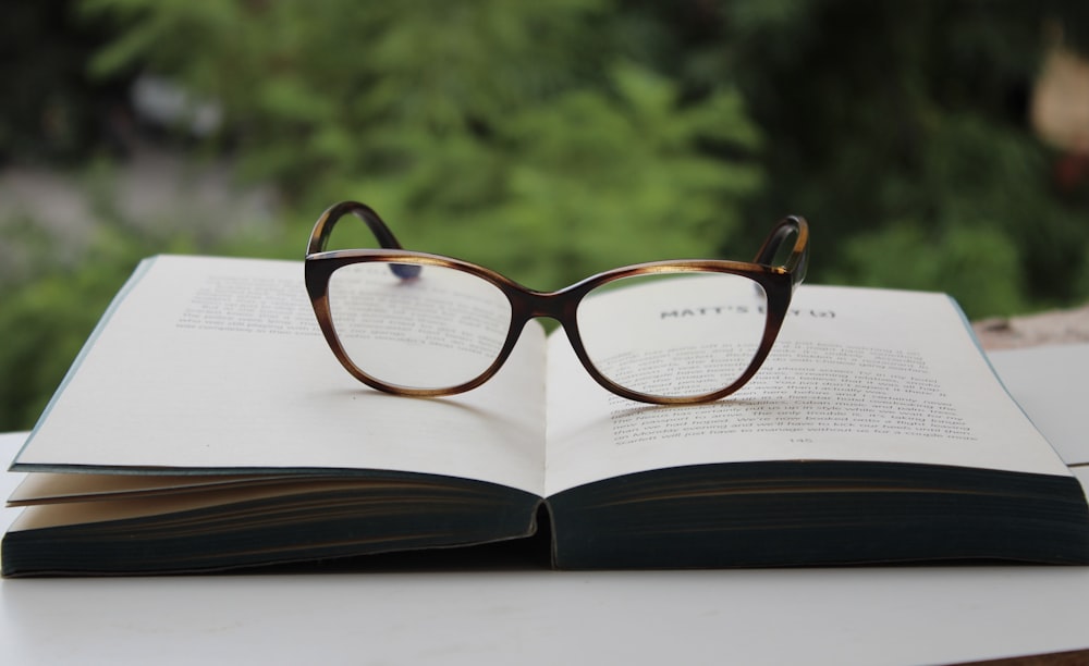 occhiali da vista con montatura marrone sulla pagina del libro