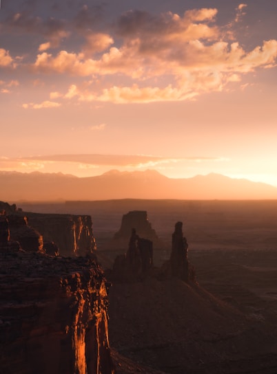 Sunset view over the ancient rock formations of AlUla, bathed in warm golden light.