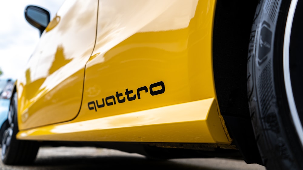 a close up of the rear end of a yellow sports car