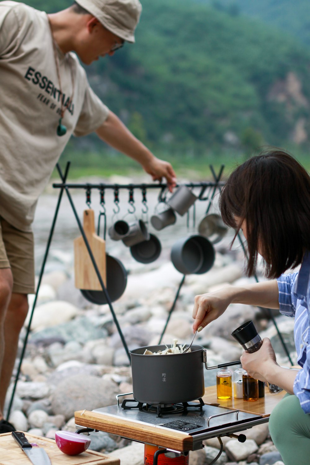 woman in white t-shirt holding black cooking pot