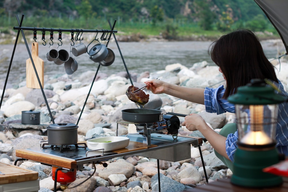 woman in blue t-shirt cooking food