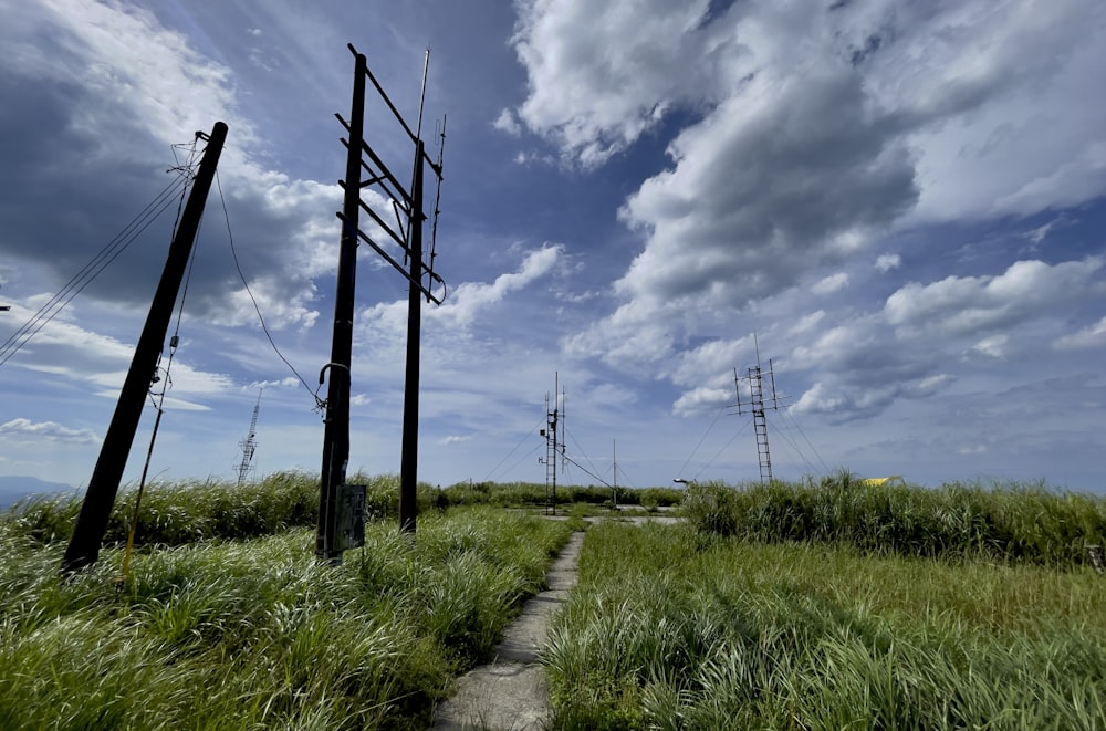 gray wooden fence on green grass field under blue sky and white clouds during daytime