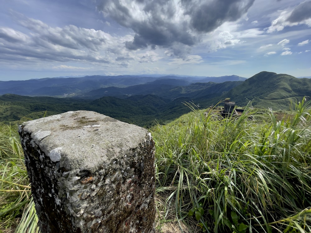 campo di erba verde e montagna sotto nuvole bianche