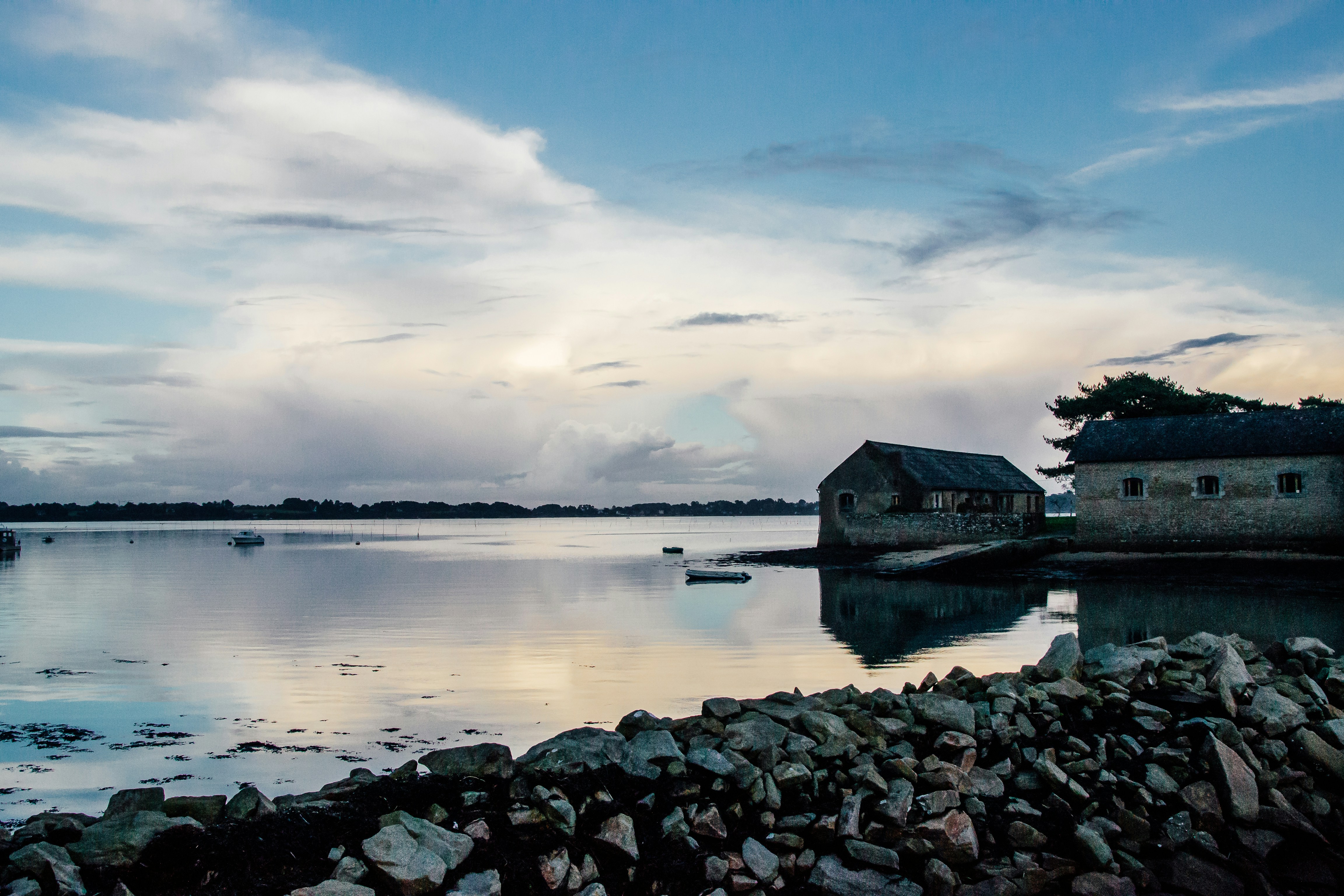 body of water near house under blue sky during daytime
