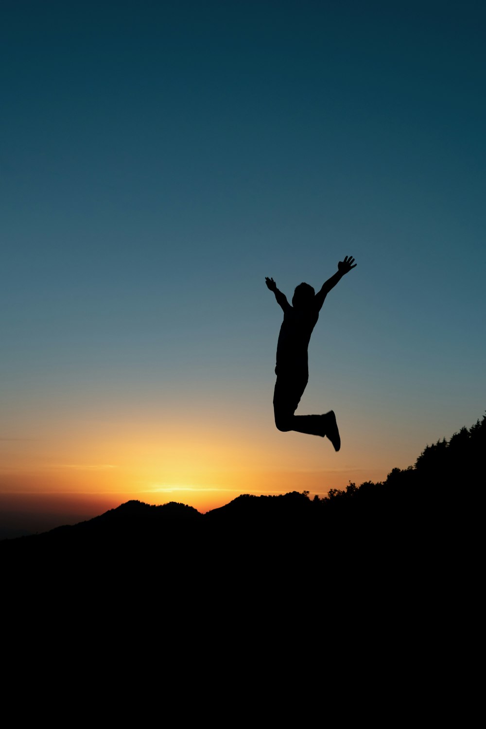 silhouette of jumping man during sunset