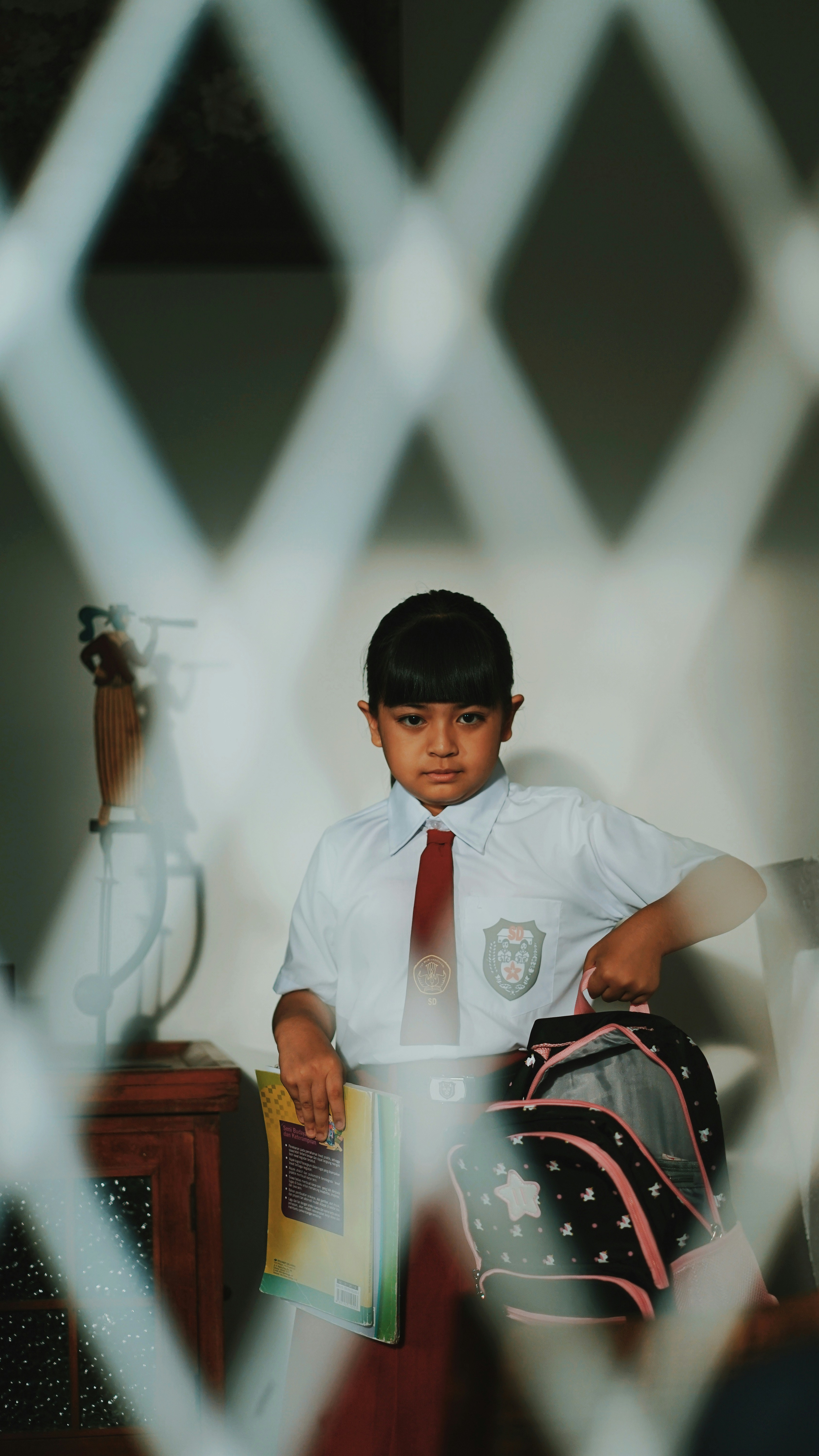 boy in white button up t-shirt wearing black cap sitting on chair