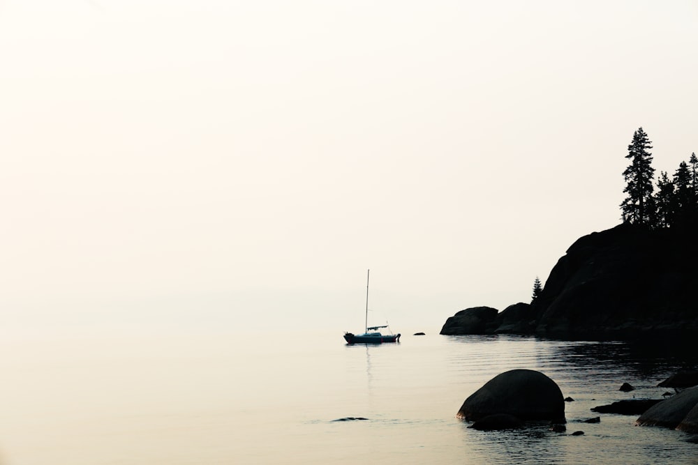 boat on sea near rock formation during daytime