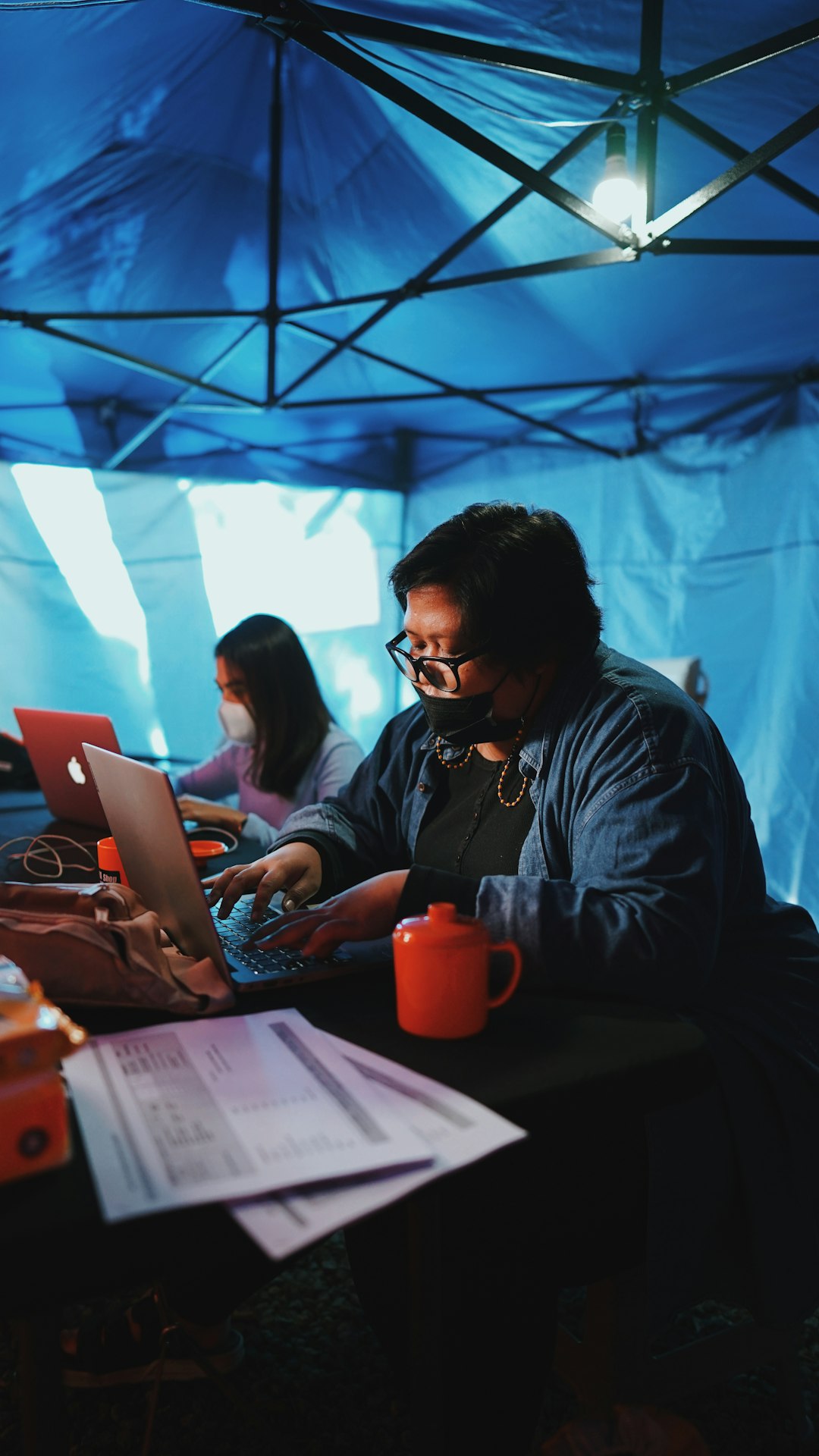 man in blue denim jacket using macbook