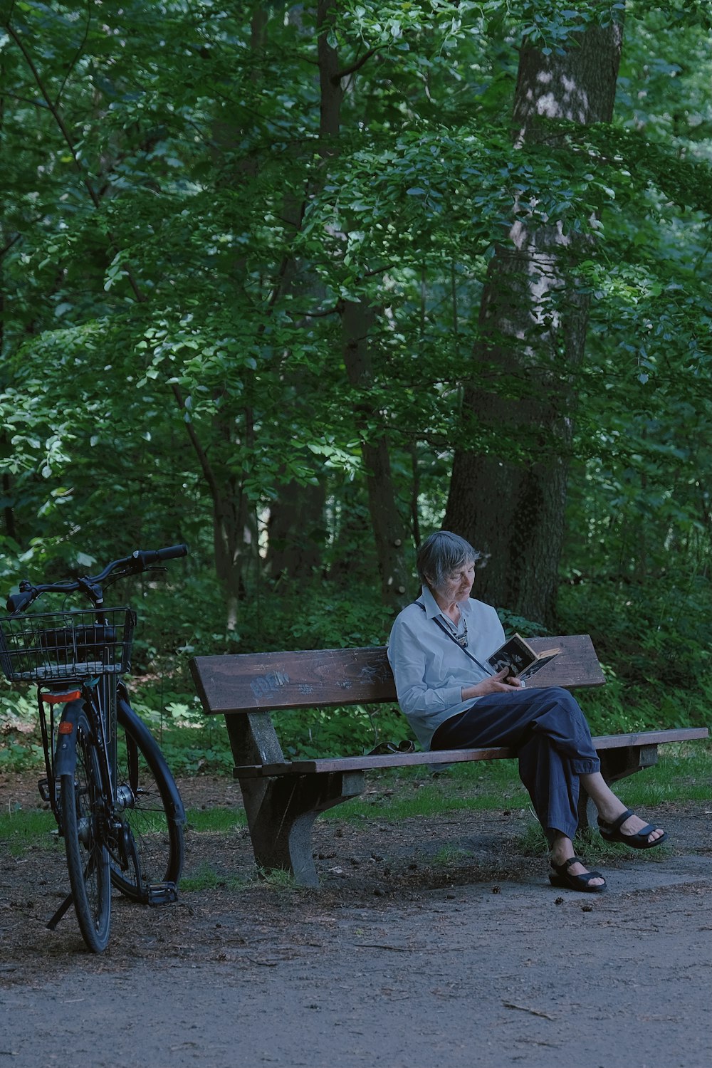 man in gray jacket sitting on brown wooden bench