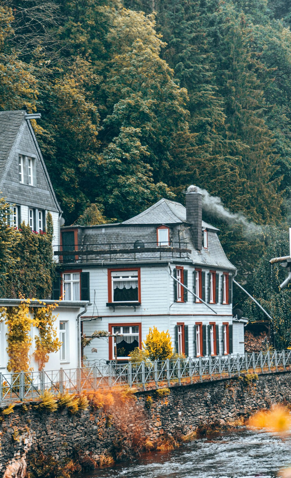 white and red wooden house surrounded by trees