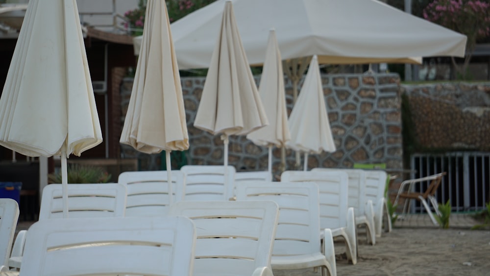 white plastic chairs on white sand beach during daytime