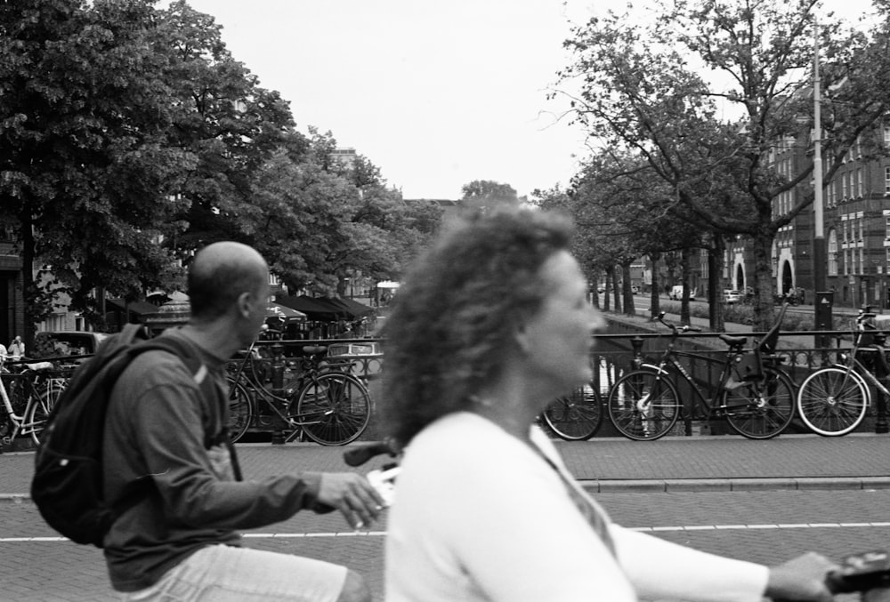 man and woman sitting on bench in grayscale photography