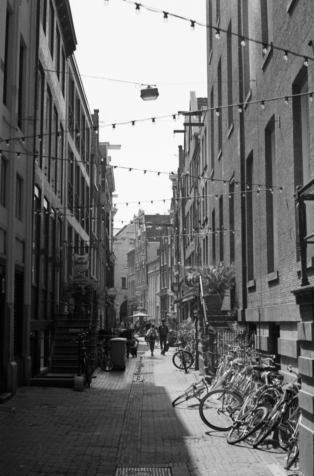 grayscale photo of bicycles parked on sidewalk