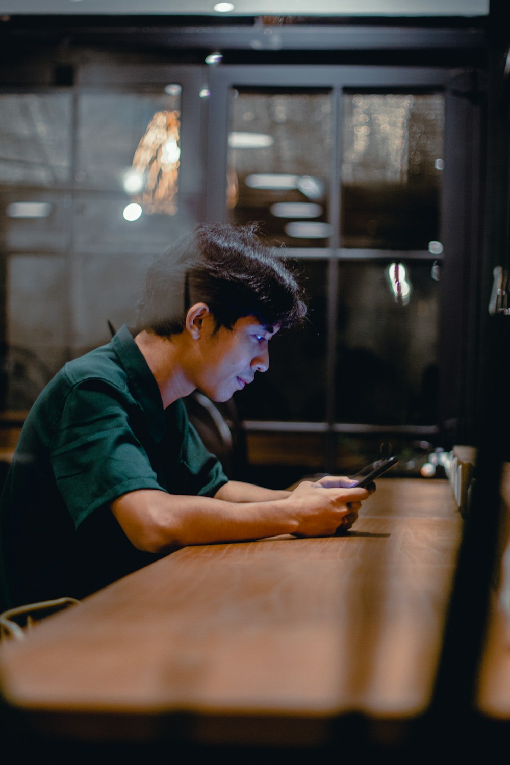 man in blue polo shirt using black smartphone