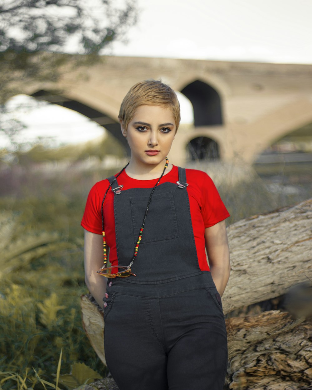 girl in red crew neck t-shirt and black denim jeans standing on green grass during